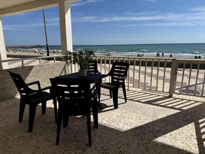 a table and chairs on a balcony with the beach at Brisa de mar in El Perelló