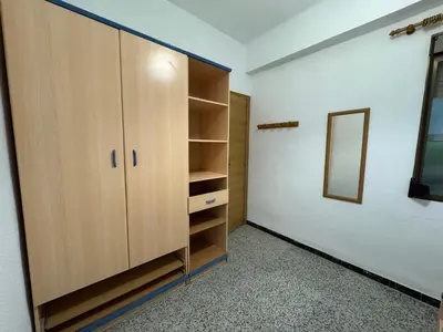 a walk in closet with wooden cabinets and a mirror at Brisa de mar in El Perelló