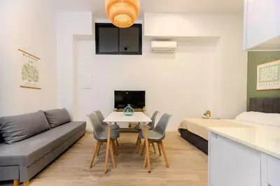 a living room with a table and a couch and a bed at Parque de Cabecera & Bioparc Apartment in Valencia