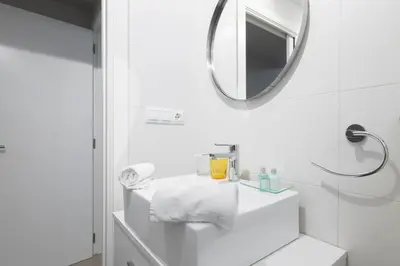 a white bathroom with a mirror and a sink at El Cabañal - Familiar in Valencia