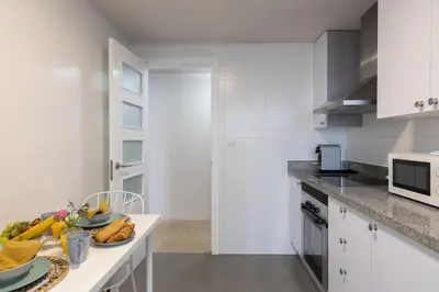 a white kitchen with a plate of food on a counter at El Cabañal - Familiar in Valencia