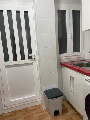 a kitchen with a white door and a sink at Apartamento Neptuno A4 in Puebla de Farnals