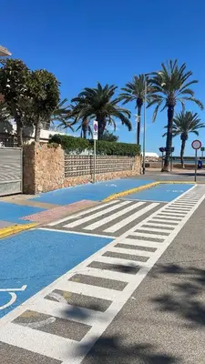 a crosswalk on a street with palm trees in the background at Apartamento Neptuno A4 in Puebla de Farnals