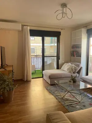 a living room with a bed and a glass table at Apartamento Neptuno A4 in Puebla de Farnals