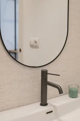 a bathroom sink with a round mirror above it at District Key - Valencia, Fuencaliente D in Valencia