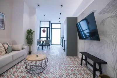 a living room with a couch and a tv on a wall at District Key - Valencia, Fuencaliente D in Valencia