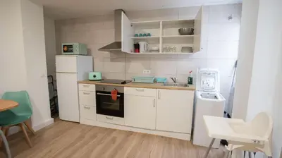 a kitchen with white cabinets and a white refrigerator at LOWCOST Beach & CityCenter in Valencia