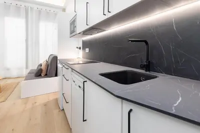 a kitchen with a sink and a black wall at Ca La Leni Beach 0 in Valencia
