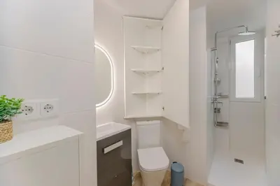 a white bathroom with a toilet and a sink at Malva Playa in Valencia