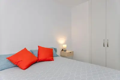 a bedroom with two red pillows on a bed at Malva Playa in Valencia