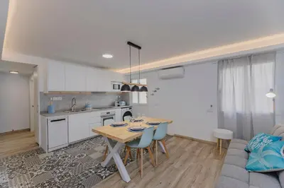 a kitchen and living room with a table and a couch at Malva Playa in Valencia