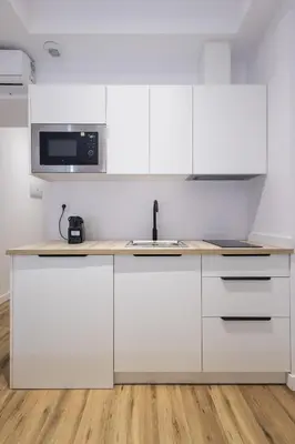 a white kitchen with a sink and a microwave at Lôla Suites by Concept Flats in Valencia