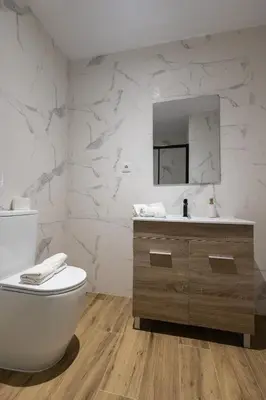 a white bathroom with a toilet and a sink at Lôla Suites by Concept Flats in Valencia