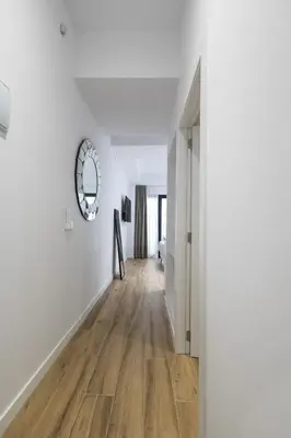 an empty hallway with white walls and wood floors at Lôla Suites by Concept Flats in Valencia