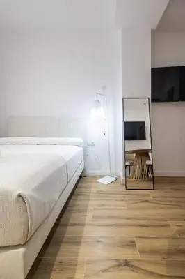a bedroom with a large bed and a mirror at Lôla Suites by Concept Flats in Valencia