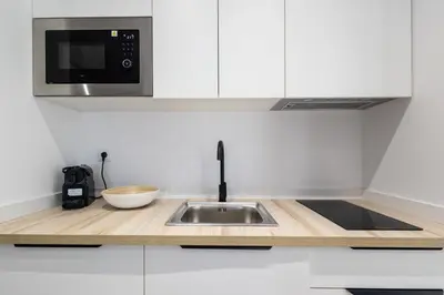 a kitchen with a sink and a microwave at Lôla Suites by Concept Flats in Valencia