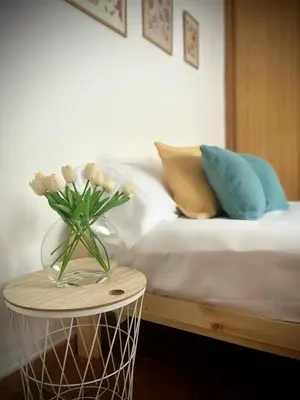 a vase of flowers on a table next to a bed at Mar in Valencia