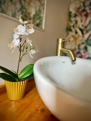 a bathroom sink with a white flower in a vase at Mar in Valencia