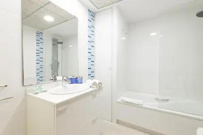 a white bathroom with a sink and a shower at Dorm4You Patacona in Valencia