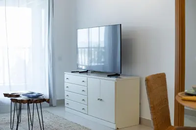 a white dresser with a tv on top of it at Dorm4You Patacona in Valencia
