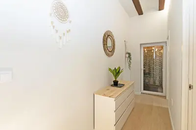a white hallway with a dresser and a mirror at Exclusivo apartamento a 5 minutos de la playa in Valencia
