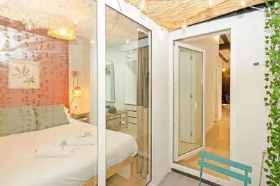 a bedroom with a white bed and a blue chair at Exclusivo apartamento a 5 minutos de la playa in Valencia
