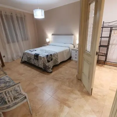 a bedroom with a bed and a chair and a ladder at Casa Crispetes in Tales