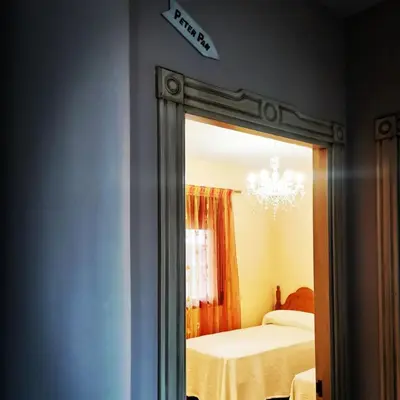a mirror in a bedroom with a bed and a chandelier at Casa Crispetes in Tales