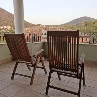 two wooden chairs sitting on top of a balcony at Casa Crispetes in Tales