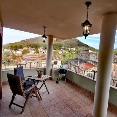 a balcony with a table and chairs and a grill at Casa Crispetes in Tales