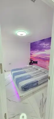 a bed in a room with a painting on the wall at Paradise Home in Valencia