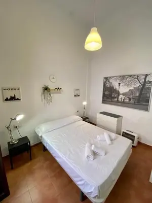 a bedroom with a bed with white sheets and pillows at Alojamiento Familiar cerca de la Playa Valencia in Valencia