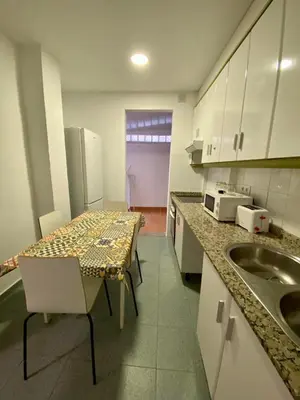a kitchen with a table and a sink in it at Alojamiento Familiar cerca de la Playa Valencia in Valencia