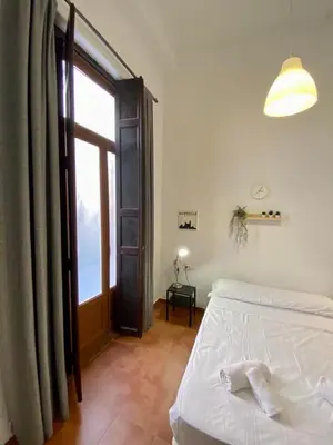 a bedroom with a bed and a large window at Alojamiento Familiar cerca de la Playa Valencia in Valencia