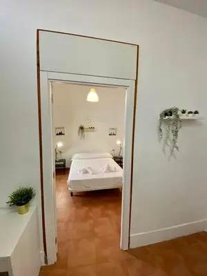 a mirror reflecting a bedroom with a bed in a room at Alojamiento Familiar cerca de la Playa Valencia in Valencia
