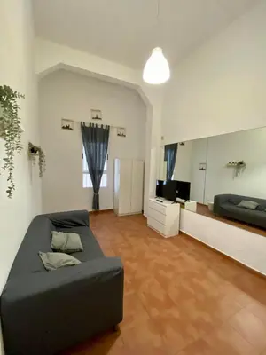 a large living room with a bed and a television at Alojamiento Familiar cerca de la Playa Valencia in Valencia