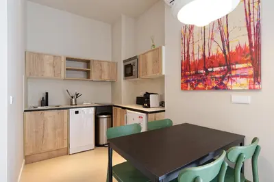 a kitchen with a table and chairs in a room at Osito Hub - Colomer in Valencia