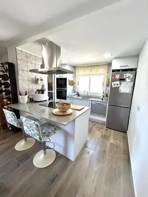 a kitchen with a counter and a refrigerator at Faro Playa de Cullera in Faro de Cullera