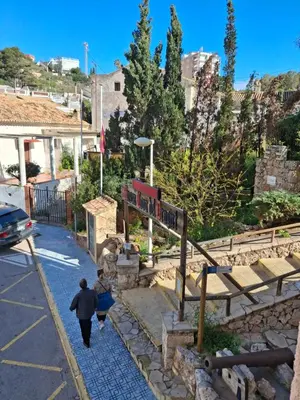 a couple of people walking down a street at Faro Playa de Cullera in Faro de Cullera