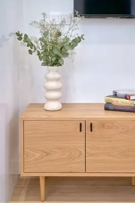 a vase of flowers sitting on top of a wooden cabinet at Romantic Suite Roig Arena N1 Virkin Suites in Valencia