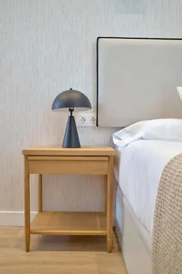 a table with a lamp on it next to a bed at Romantic Suite Roig Arena N1 Virkin Suites in Valencia