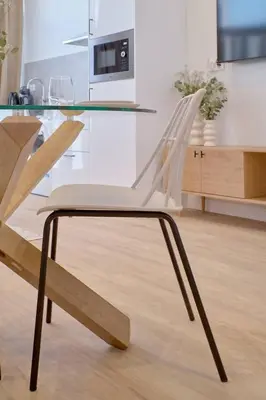 a glass table with two white chairs in a kitchen at Romantic Suite Roig Arena N1 Virkin Suites in Valencia