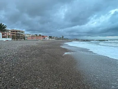 a beach with a cloudy sky and the ocean at Wohnung in Moncófar