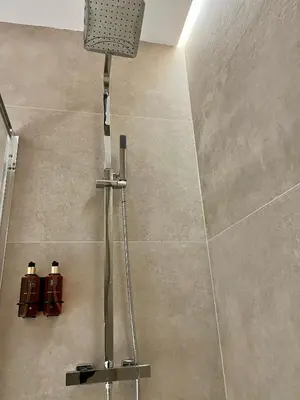 a shower in a bathroom with a tile wall at Osito Hub - Florista in Valencia