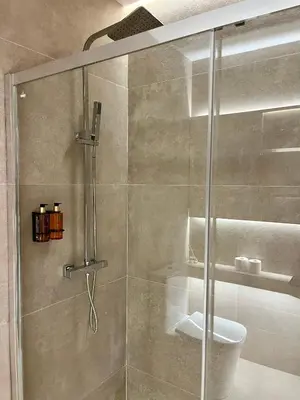 a shower with a glass door in a bathroom at Osito Hub - Florista in Valencia