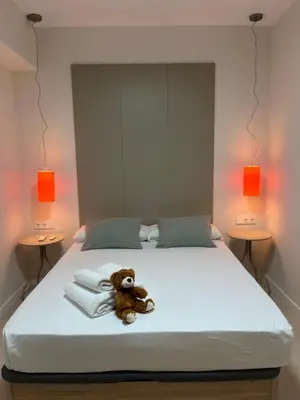 a teddy bear sitting on a bed with towels at Osito Hub - Florista in Valencia