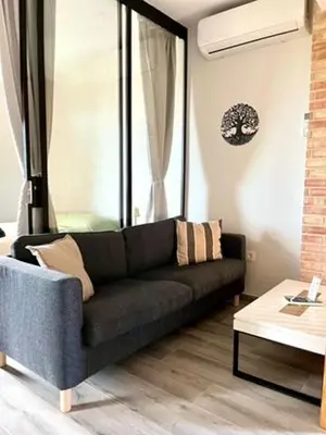 a living room with a black couch and a table at Elegante apartamento boutique a 5 min del metro in Bétera