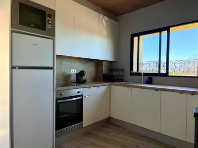 a kitchen with white cabinets and a large window at Elegante apartamento boutique a 5 min del metro in Bétera