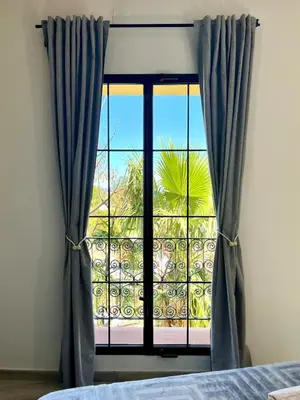 a bedroom with a window with blue curtains at Elegante apartamento boutique a 5 min del metro in Bétera