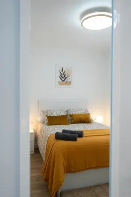 a bedroom with a bed with two mitts on it at Zabas FLAT in Alboraya